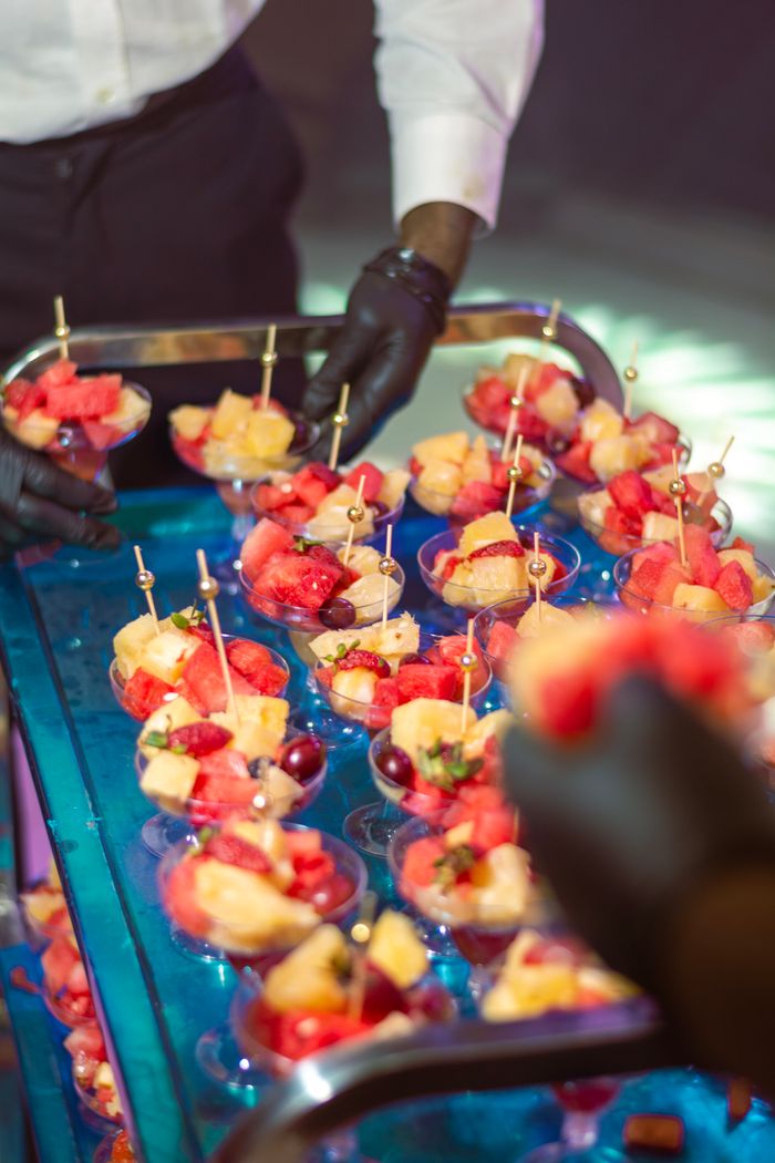 Vibrant fruit salad cups prepared by catering staff, perfect for parties and events.